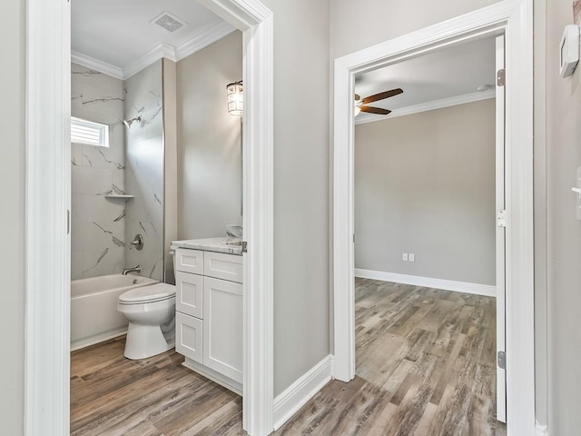 full bathroom featuring ornamental molding, vanity, hardwood / wood-style floors, toilet, and tiled shower / bath