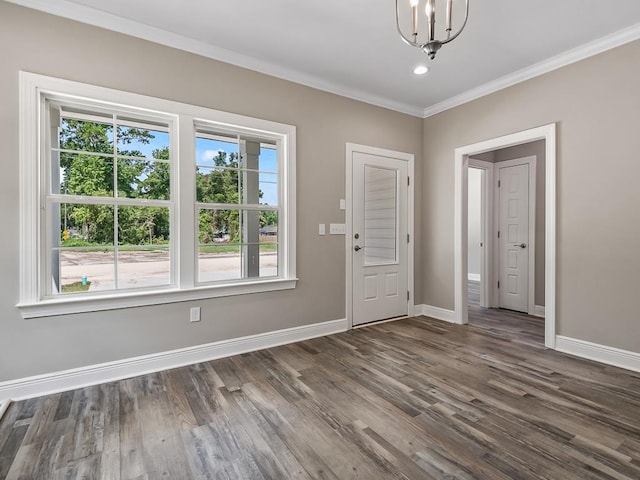 entrance foyer with dark hardwood / wood-style flooring, crown molding, and an inviting chandelier