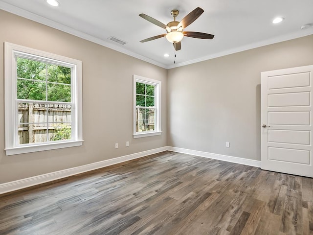 empty room featuring crown molding, plenty of natural light, and dark wood-type flooring