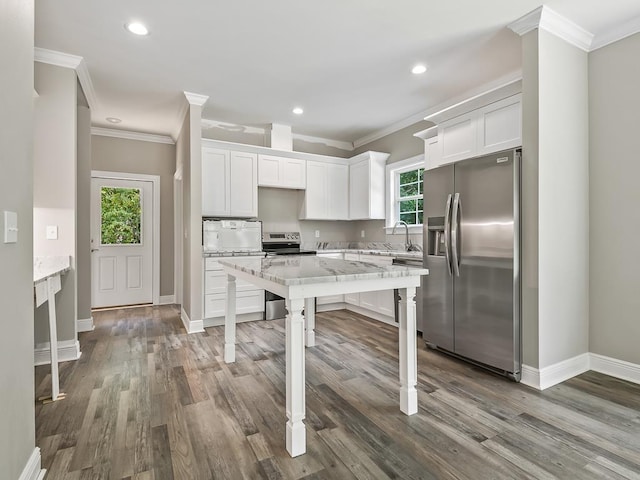 kitchen with light stone counters, stainless steel appliances, crown molding, sink, and white cabinets