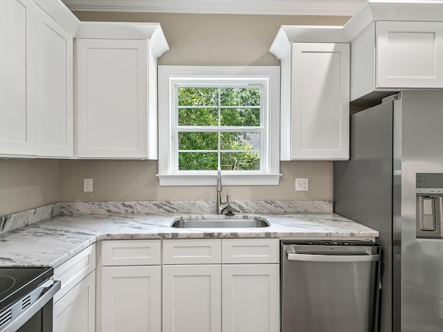 kitchen featuring stainless steel appliances, white cabinetry, and sink