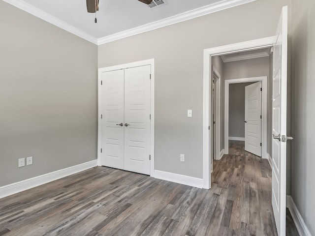 unfurnished bedroom featuring a closet, crown molding, dark hardwood / wood-style flooring, and ceiling fan