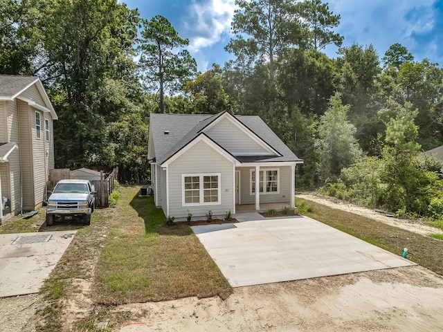 view of front of property with central air condition unit and a front yard