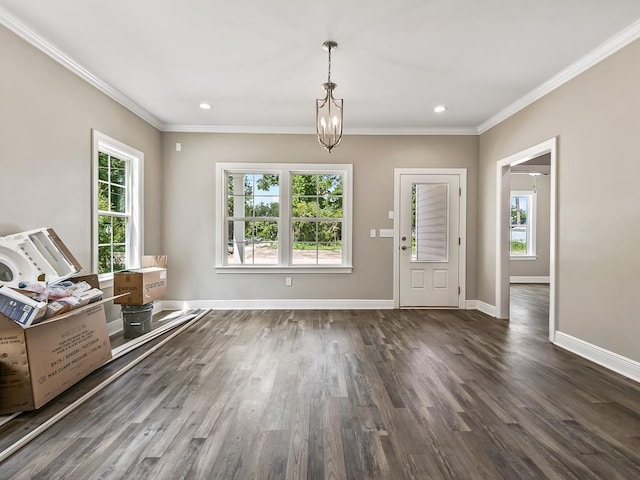 foyer with dark hardwood / wood-style floors, crown molding, and a chandelier