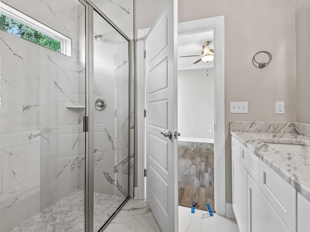 bathroom featuring ceiling fan, hardwood / wood-style floors, vanity, and walk in shower