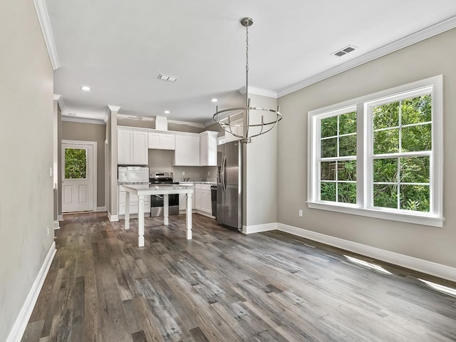 kitchen with white cabinets, appliances with stainless steel finishes, hanging light fixtures, and dark wood-type flooring