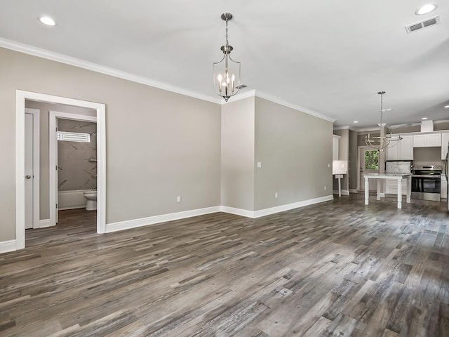 unfurnished living room with dark hardwood / wood-style floors, ornamental molding, and an inviting chandelier