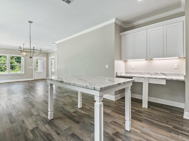 kitchen with dark hardwood / wood-style floors, white cabinetry, hanging light fixtures, and ornamental molding