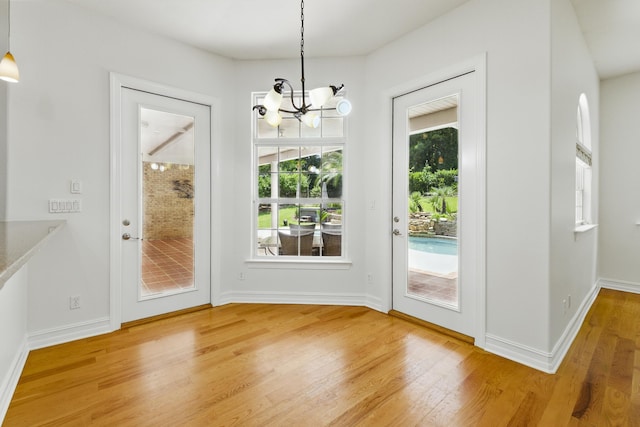 9227 Shoal Creek Dr, Tallahassee, FL 32312 - doorway to outside with light wood-type flooring, a chandelier, and baseboards
