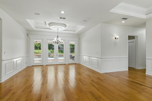 9227 Shoal Creek Dr, Tallahassee, FL 32312 - unfurnished room featuring a tray ceiling, a chandelier, crown molding, light wood-type flooring, and a decorative wall