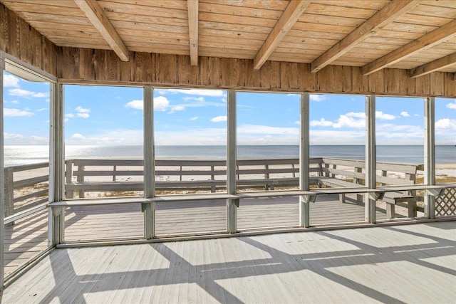 unfurnished sunroom featuring a water view, a beach view, and wooden ceiling