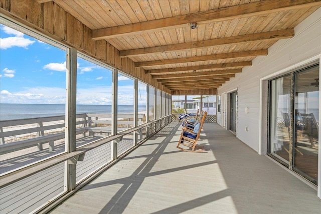 interior space featuring a water view, a balcony, and a view of the beach