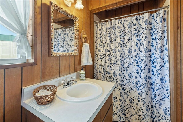 bathroom with vanity and wood walls