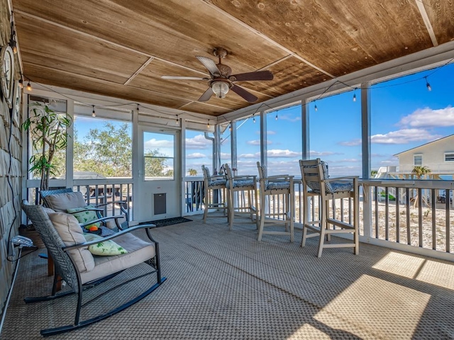 sunroom featuring ceiling fan and wooden ceiling