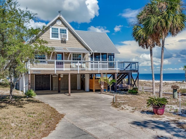 view of front of house with a water view, a garage, a view of the beach, and a carport