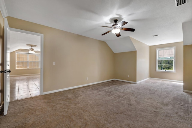 bonus room featuring carpet floors, tile patterned flooring, visible vents, and vaulted ceiling