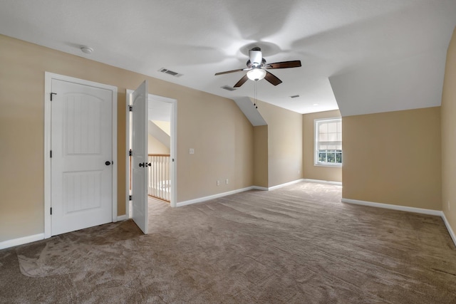 additional living space with carpet, visible vents, vaulted ceiling, and baseboards