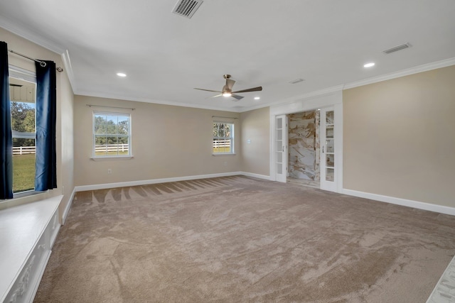 unfurnished room with ornamental molding, light colored carpet, visible vents, and baseboards