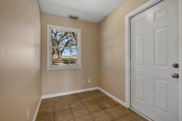 interior space with light tile patterned floors, visible vents, and baseboards