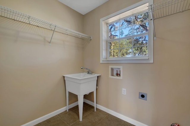 laundry area featuring hookup for a washing machine, hookup for an electric dryer, laundry area, dark tile patterned flooring, and baseboards