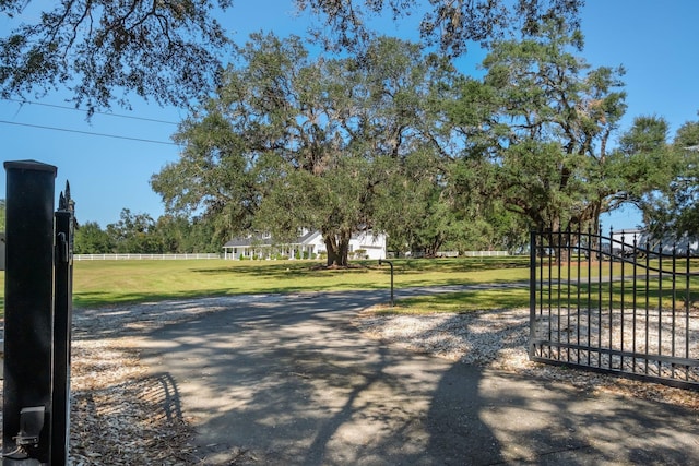 view of gate with a lawn and fence