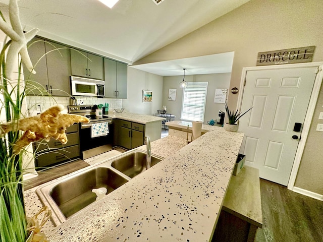 kitchen with green cabinetry, dark hardwood / wood-style flooring, lofted ceiling, pendant lighting, and appliances with stainless steel finishes