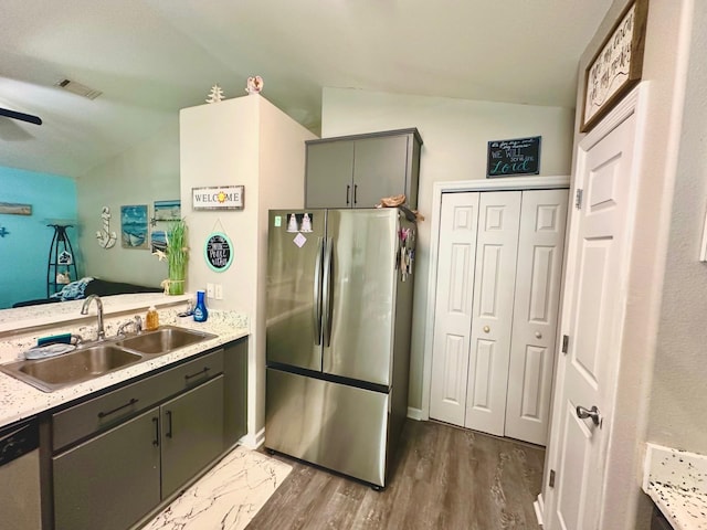 kitchen with sink, vaulted ceiling, stainless steel refrigerator, and dark hardwood / wood-style floors