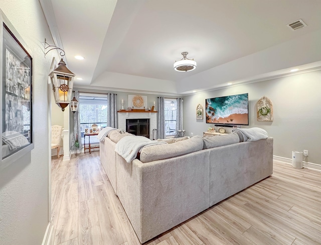 2825 Turkey Hill Trl, Tallahassee, FL 32312 - living room with light wood-style floors, a raised ceiling, baseboards, a brick fireplace, and visible vents