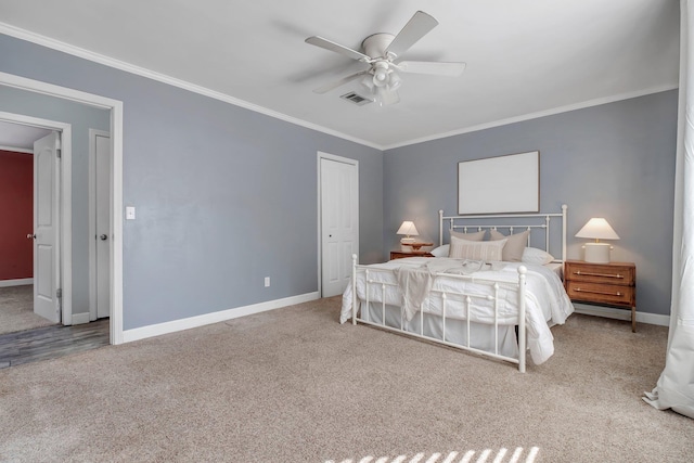 carpeted bedroom featuring ornamental molding, ceiling fan, and a closet