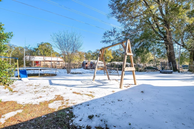 snow covered playground with a trampoline