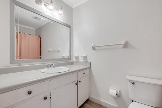 bathroom with crown molding, wood-type flooring, vanity, and toilet