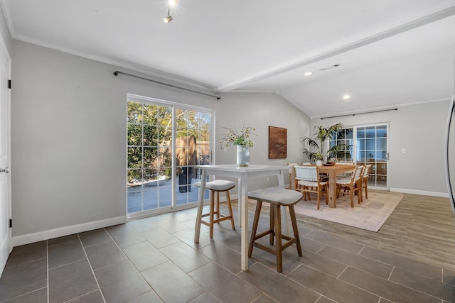 dining room with crown molding and vaulted ceiling with beams