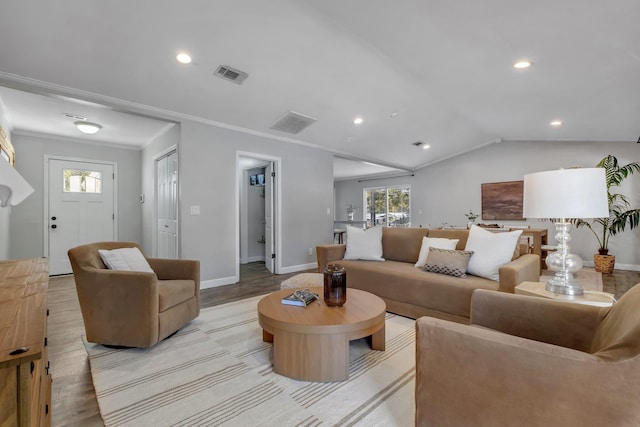 living room featuring lofted ceiling, light hardwood / wood-style flooring, and ornamental molding