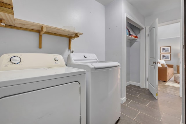 laundry room with dark tile patterned flooring and washing machine and dryer