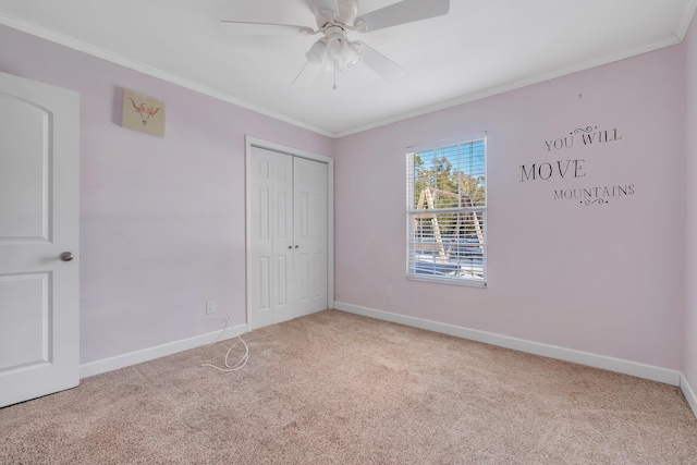 unfurnished bedroom featuring ornamental molding, light carpet, ceiling fan, and a closet