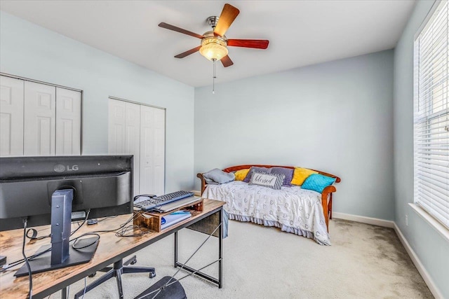 bedroom featuring light carpet, a ceiling fan, and baseboards