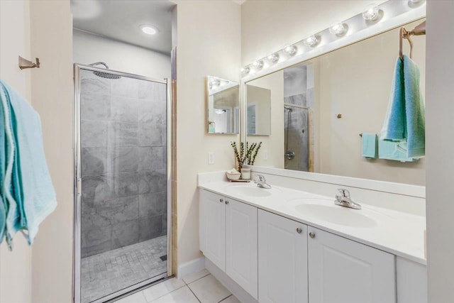 full bath featuring double vanity, a shower stall, a sink, and tile patterned floors