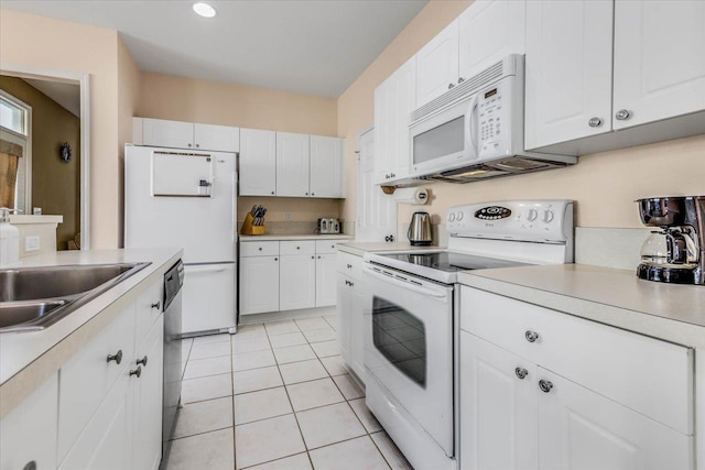 kitchen with white appliances, light countertops, and white cabinetry