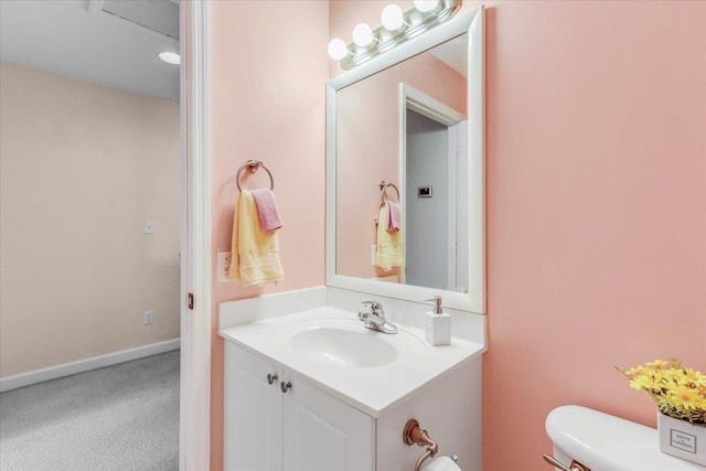 bathroom featuring baseboards, vanity, and toilet