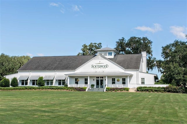 view of front of home featuring a chimney, a front lawn, and a porch