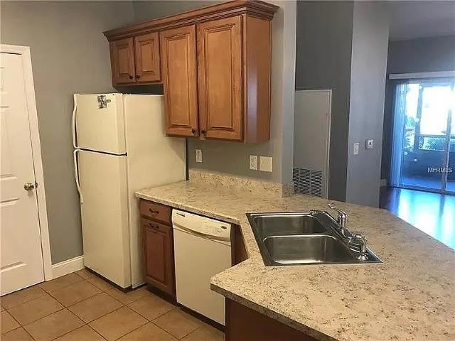 kitchen with light tile patterned flooring, white appliances, and sink