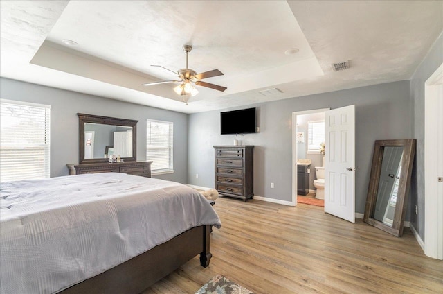 489 Charles Willis Dr, Midway, FL 32343 - bedroom with a tray ceiling, light wood-style flooring, multiple windows, and baseboards