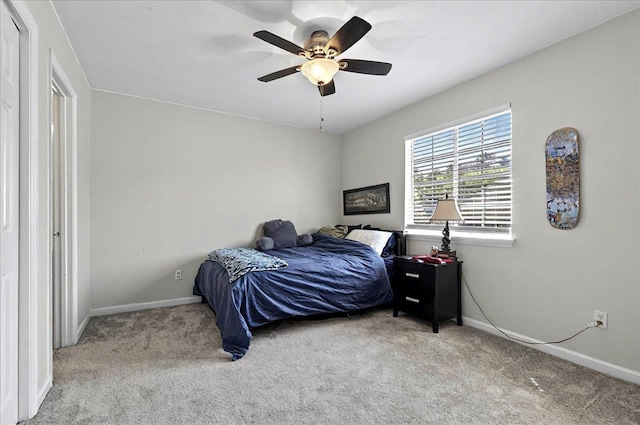 carpeted bedroom with ceiling fan and baseboards