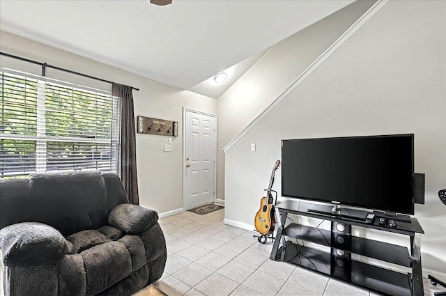 living area featuring light tile patterned floors, vaulted ceiling, and baseboards
