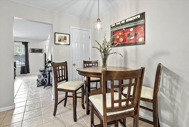 dining space featuring baseboards and light tile patterned flooring
