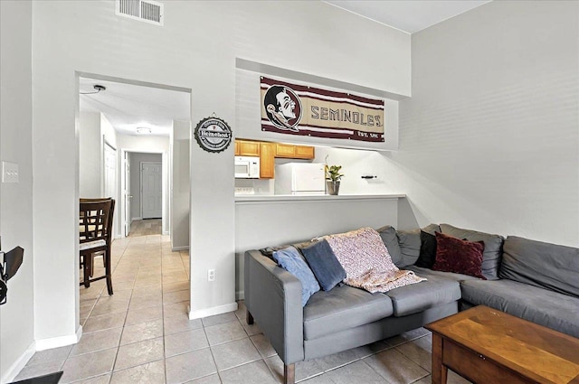living room featuring baseboards, visible vents, and light tile patterned floors