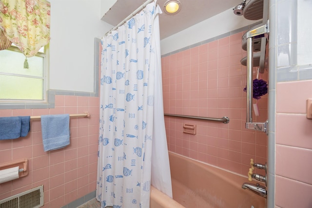 bathroom featuring tile walls and shower / tub combo with curtain