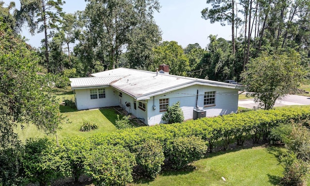 rear view of property with a yard and central AC