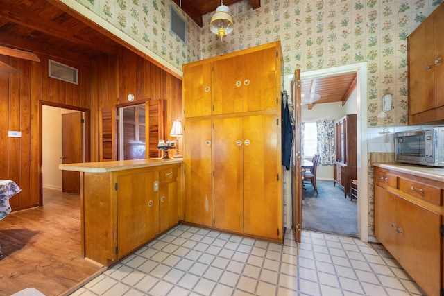 kitchen featuring wooden walls and kitchen peninsula