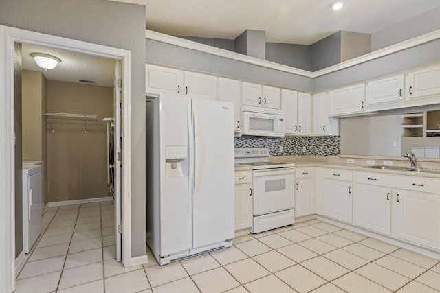 kitchen with light tile patterned floors, light countertops, white cabinets, a sink, and white appliances